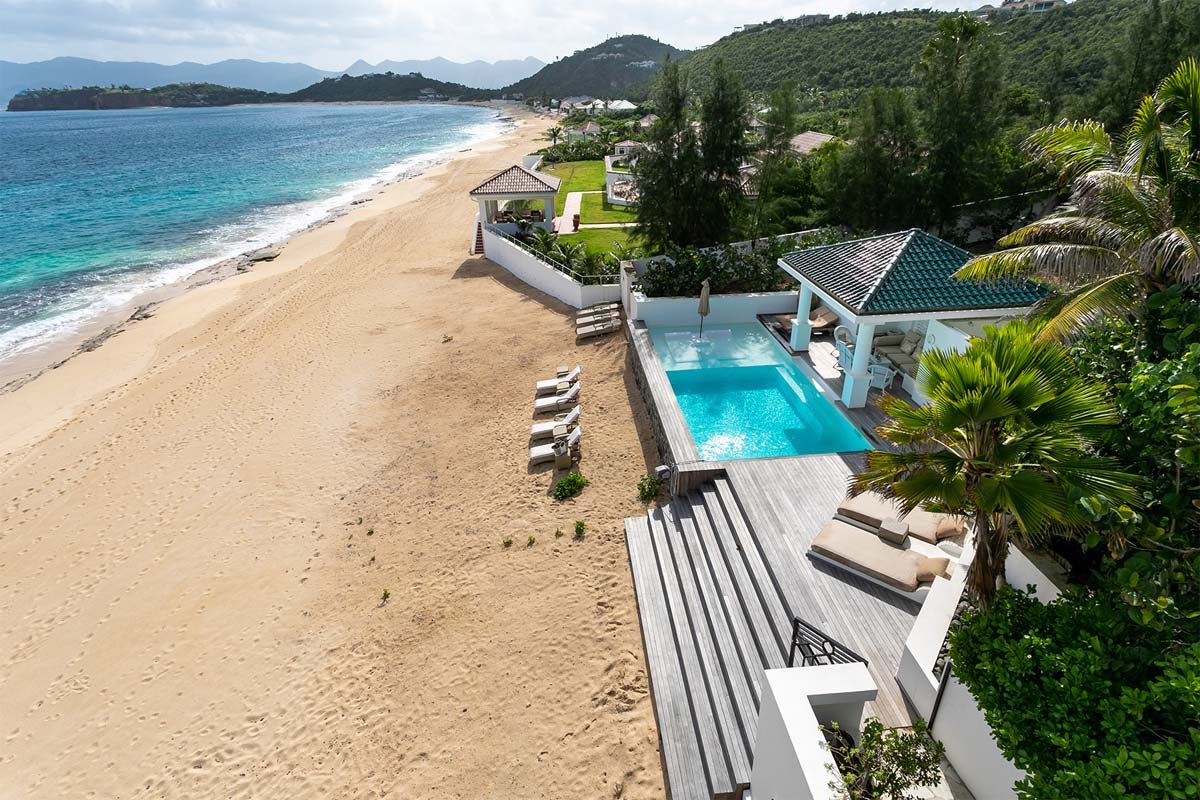 "Beachfront pool with submerged daybeds, loungers, and gazebo at Villa L'Oasis, Terres Basses, St. Martin