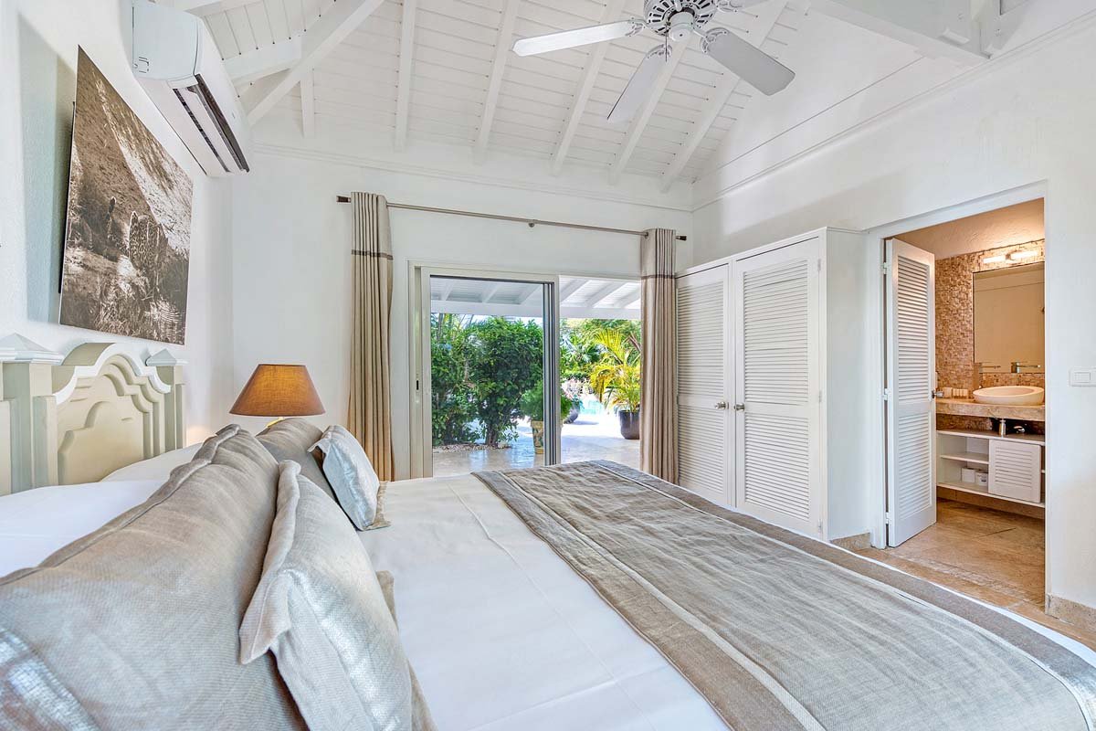 Bright, airy bedroom interior at La Pinta villa in St. Maarten with garden view