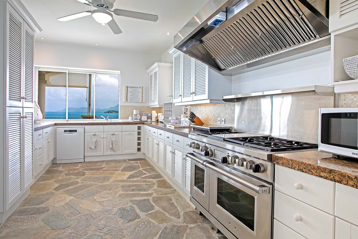 Gourmet kitchen with white cabinetry, quartz countertops, and ocean views at Villa L'Oasis, Terres Basses, St. Martin.