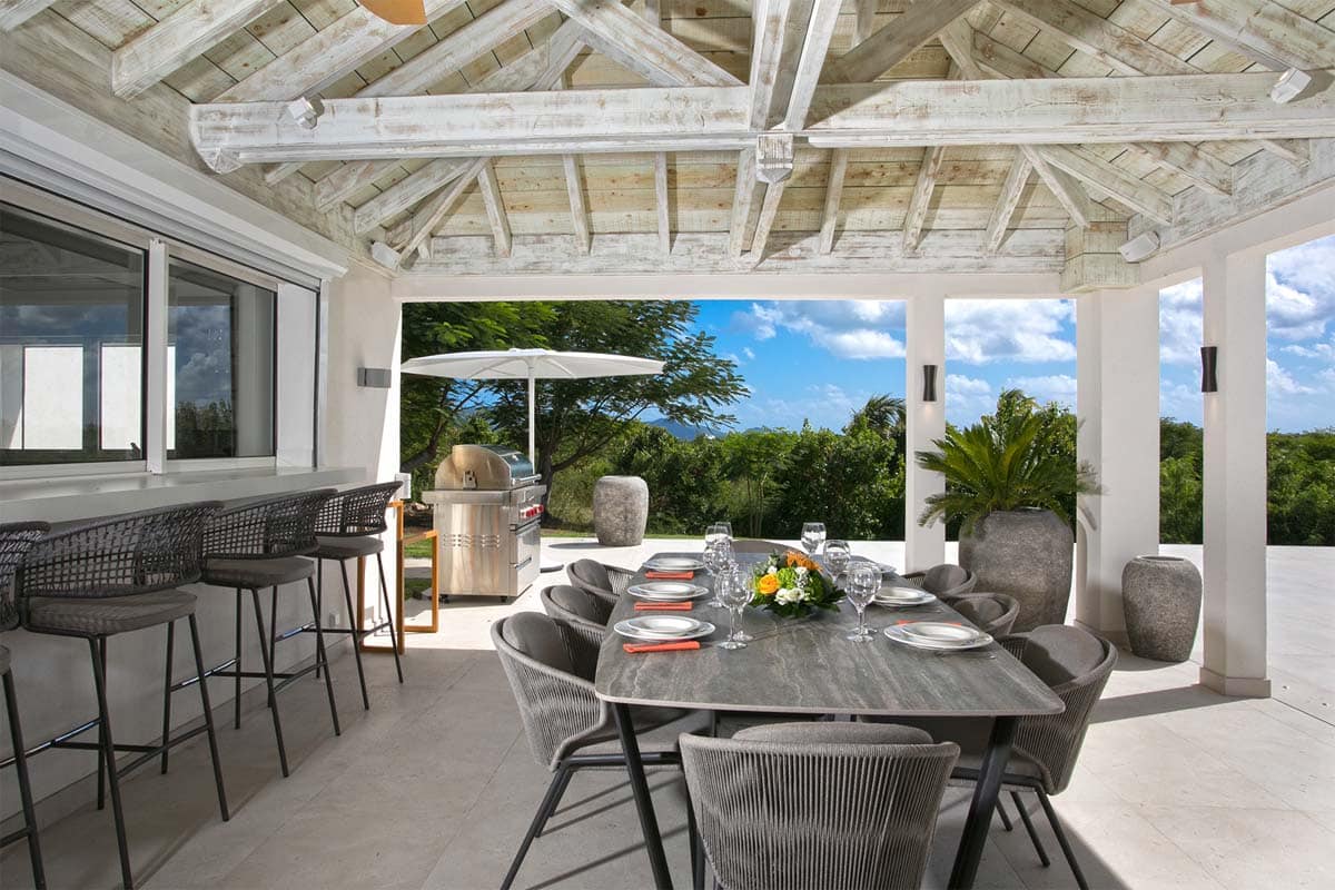 Outdoor dining area with seating for 8, Wolf gas grill, and ocean view at Villa Avanti, St. Martin.