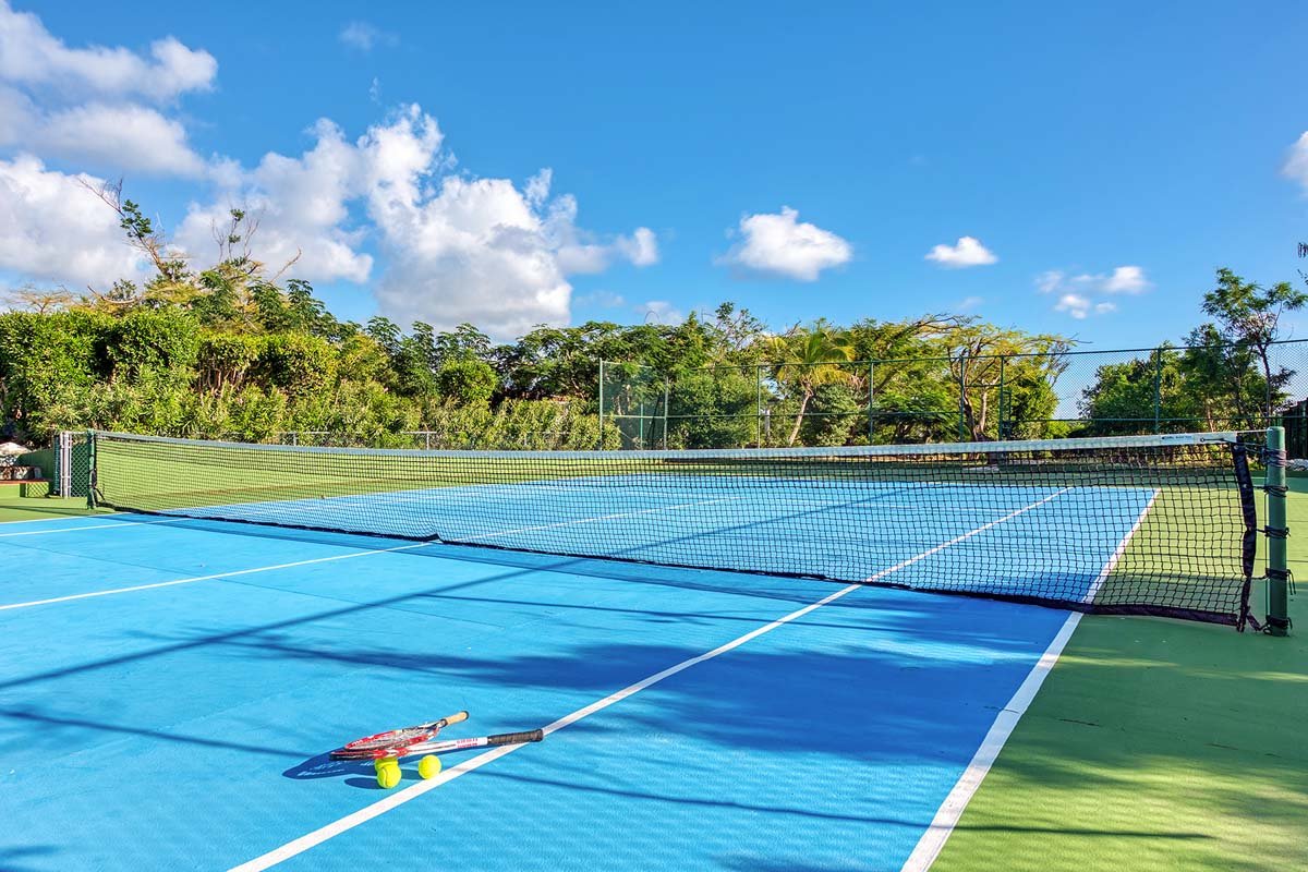 Outdoor tennis court at La Pinta villa in St. Maarten, lush tropical surroundings