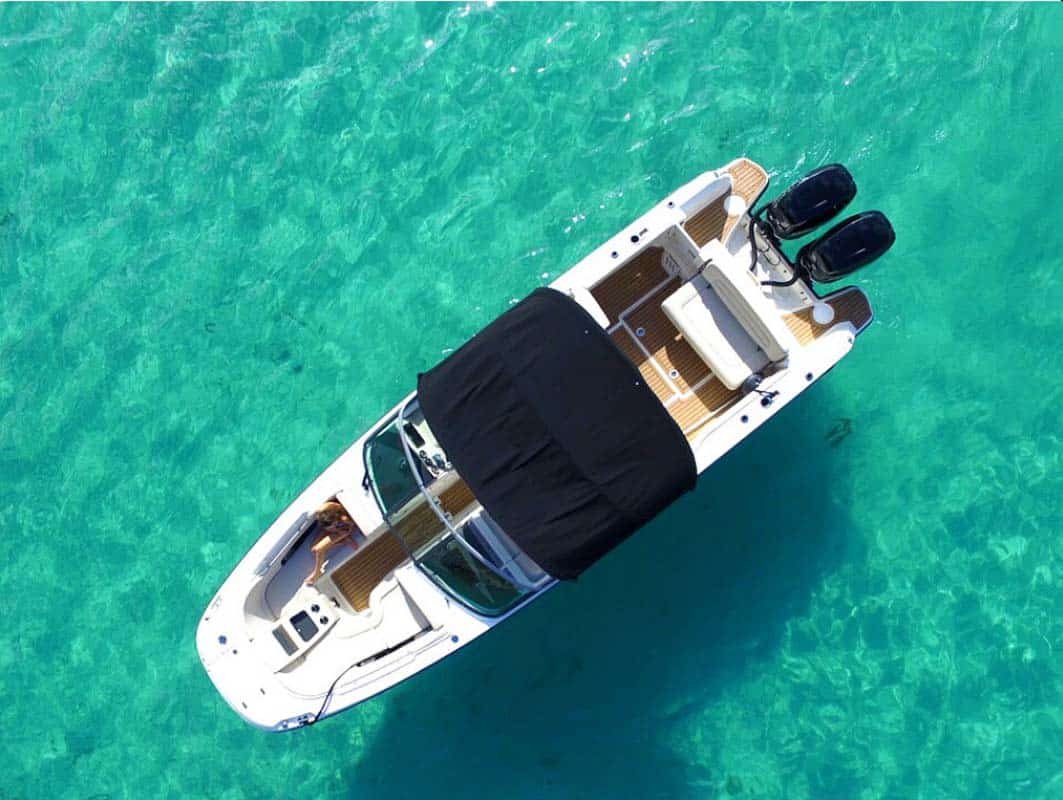 Side and top view of a Boston Whaler center console boat, showcasing its durable design and open layout.