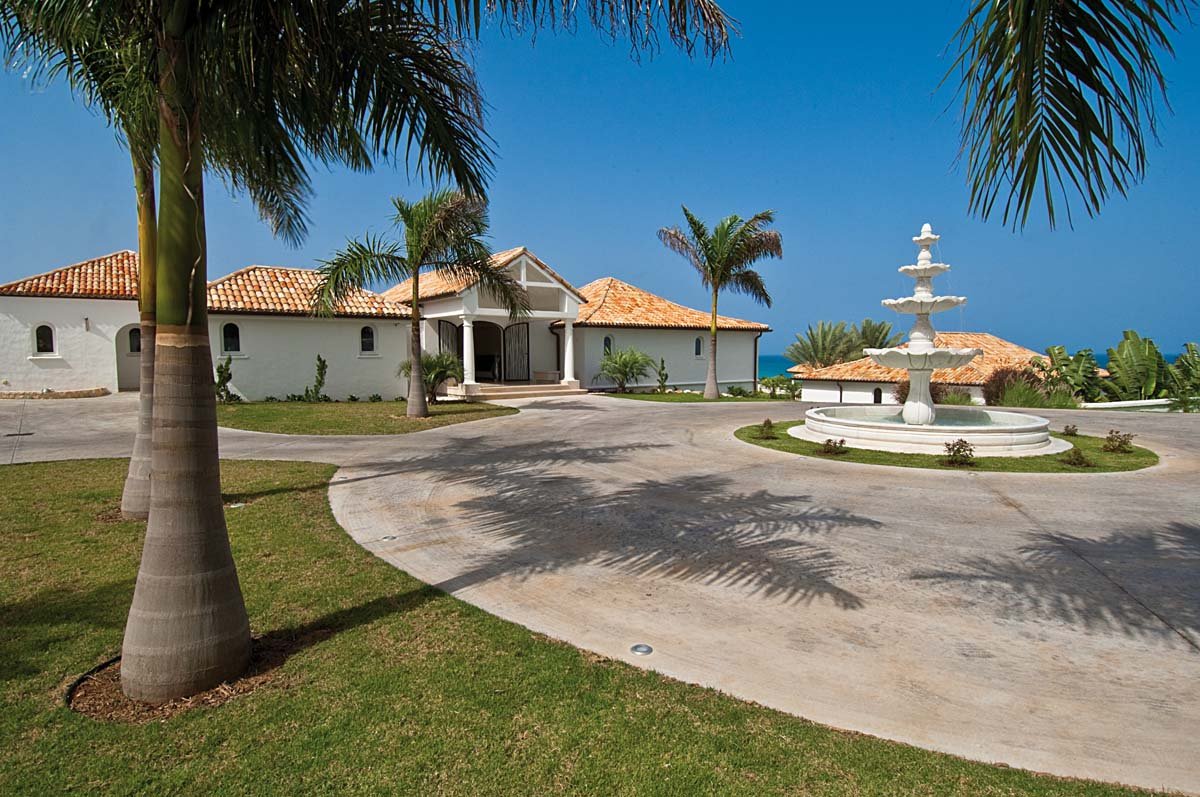 Grand entrance of Sandyline Estate with palm-lined driveway in Terres Basses, St. Martin