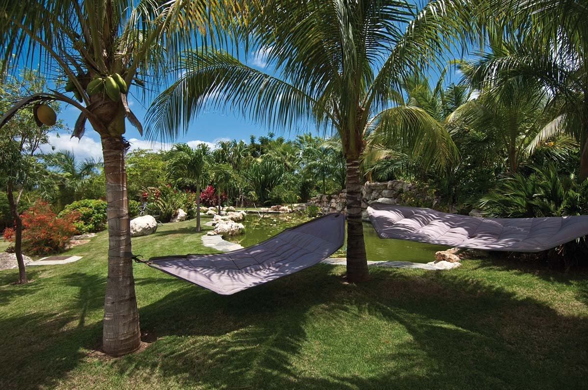 Tranquil koi pond surrounded by lush tropical foliage at Villa Sandyline, Terres Basses, St. Martin