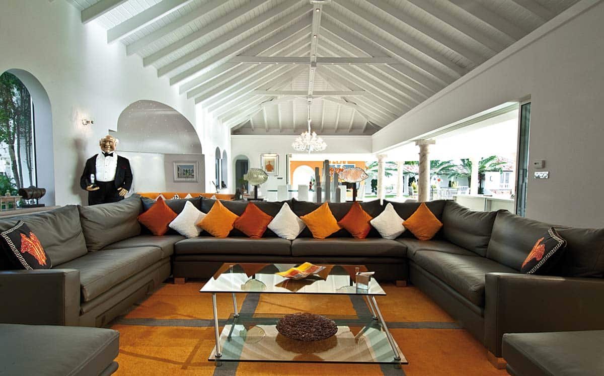 Spacious living room with leather sofas, home cinema, and ocean view at Villa Sandyline, Terres Basses, St. Martin