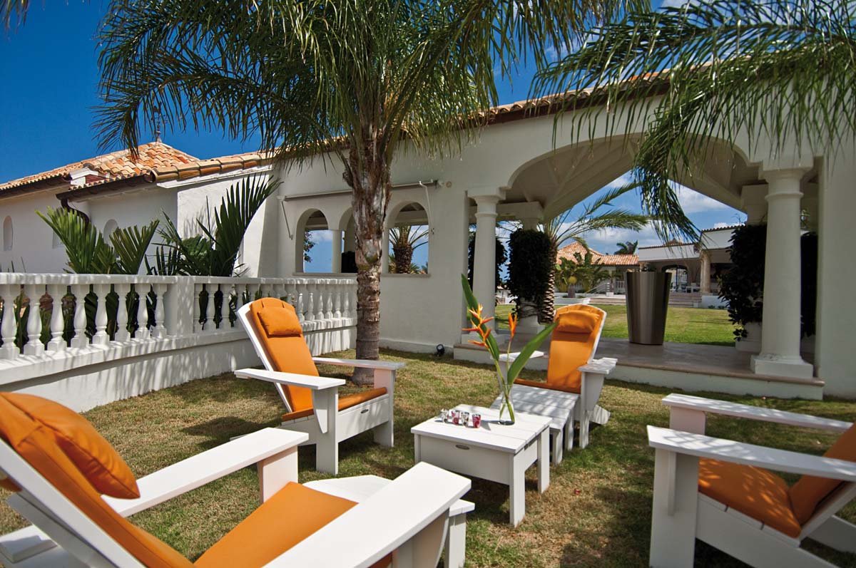 Outdoor living area with shaded seating and ocean view at Villa Sandyline, Terres Basses, St. Martin