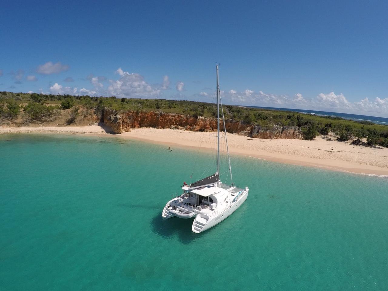 Sleek 38-ft catamaran sailing on blue sea, luxury charter in St. Maarten