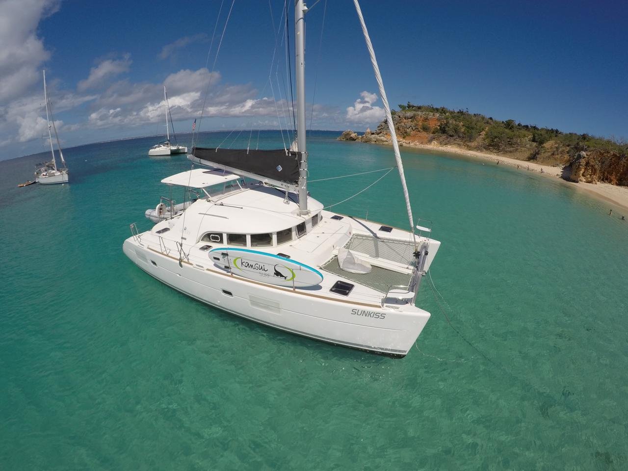 White 38-ft catamaran cruising turquoise water, luxury charter in St. Maarten