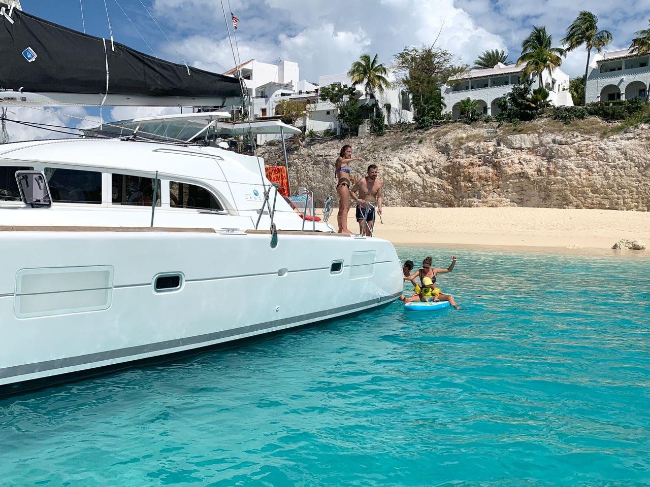 White-38 ft catamaran sailing over turquoise water, luxury charter boat in St. Maarten
