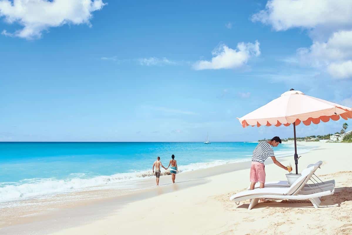 Beach service setup with lounge chairs and umbrellas at Belmond La Samanna, St. Maarten