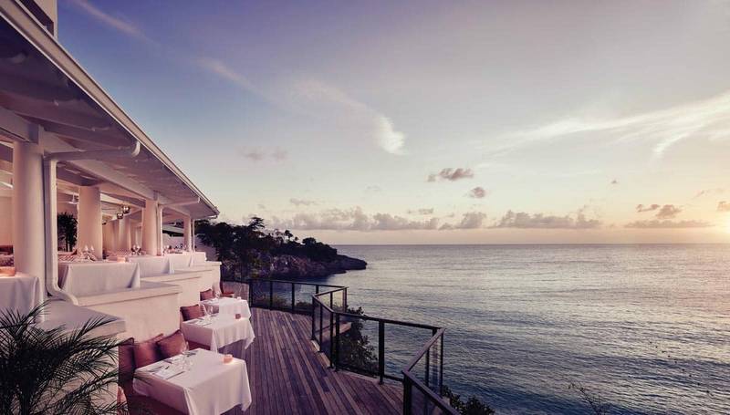 L'Oursin Restaurant at Belmond La Samanna, offering clifftop dining with panoramic sunset views over Baie Longue Beach in St. Martin.