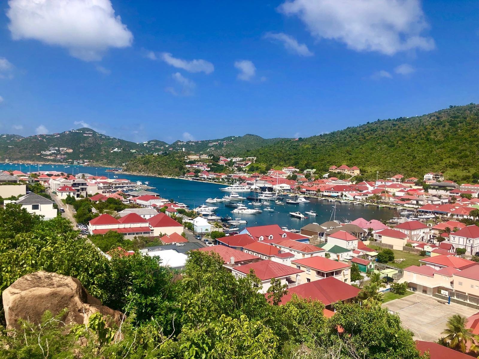 Aerial view of Gustavia harbour in St. Barths with colourful rooftops and turquoise sea.