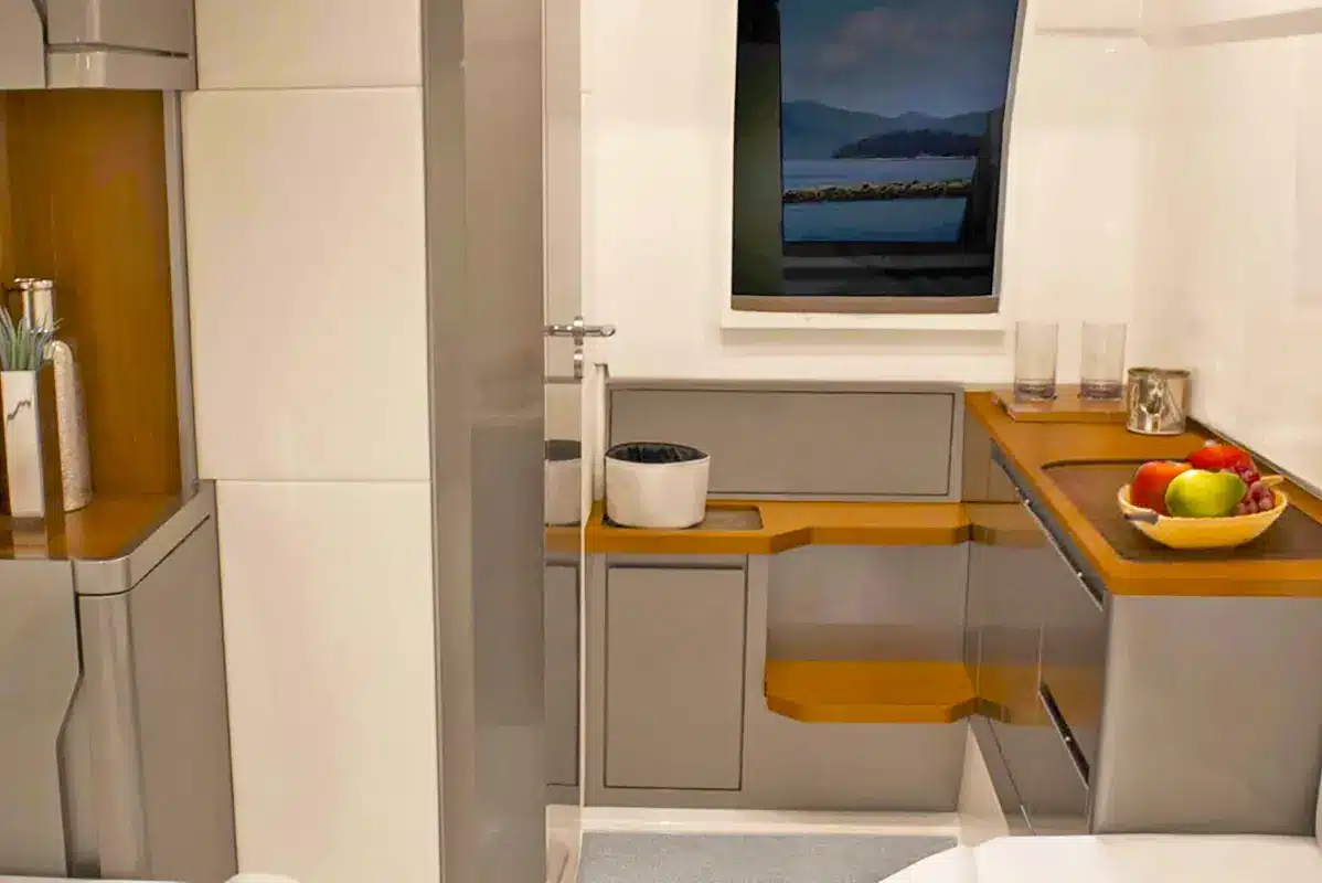 Interior of the Stellar 34ft yacht, showcasing a spacious cabin with high ceilings, plush seating, and a modern bathroom with shower