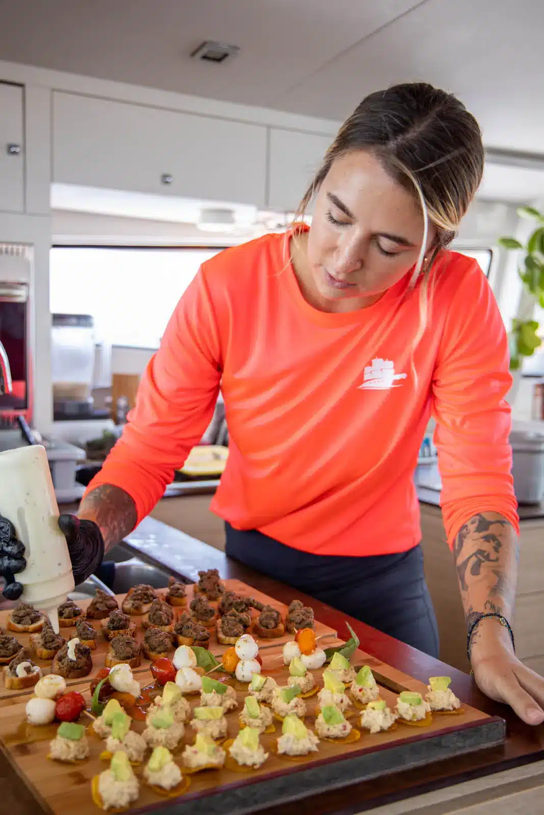 Crew serving appetizers aboard catamaran against St. Maarten’s ocean backdrop