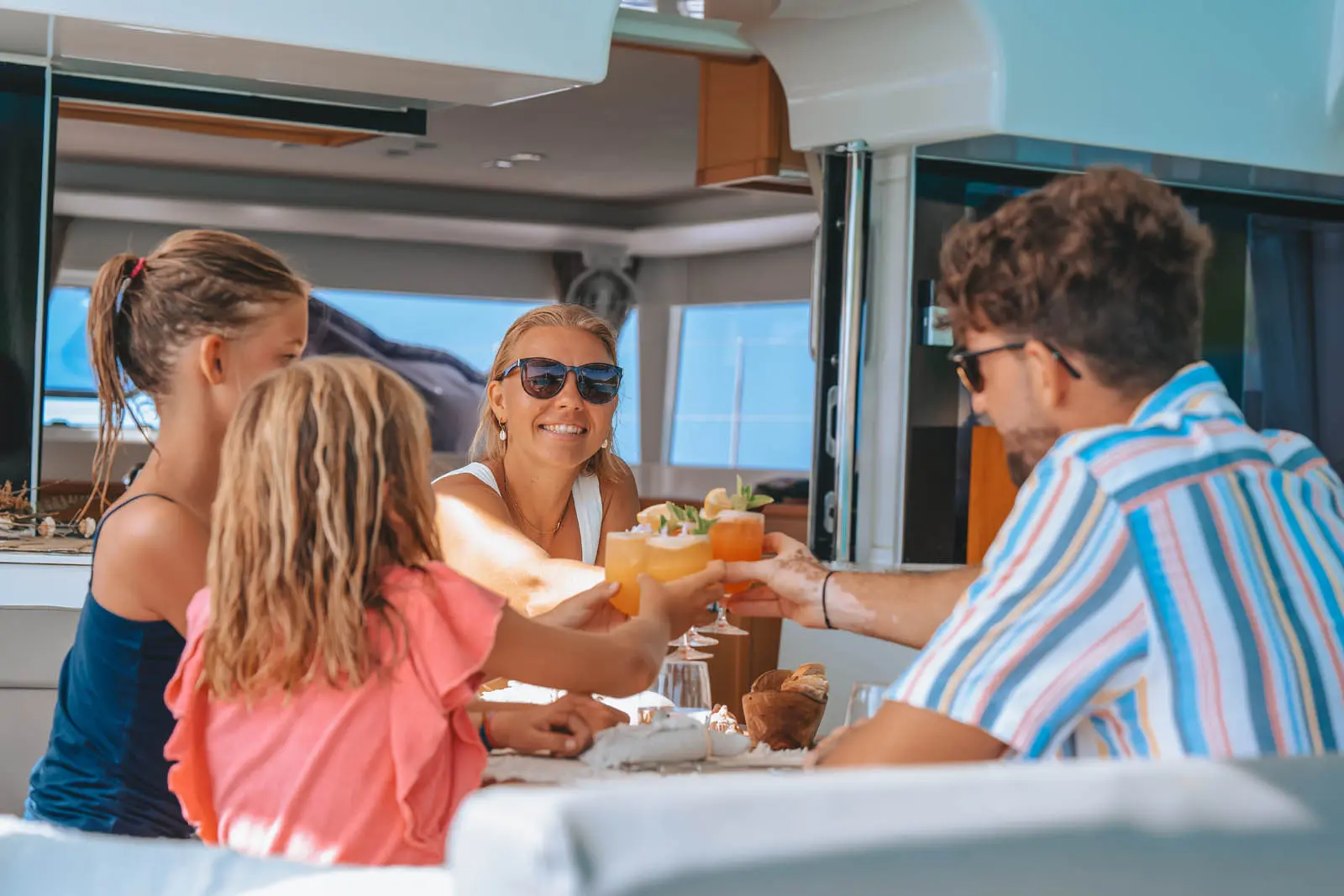 Cocktails being served on Amari Lagoon 450S deck under sunset skies off St. Maarten